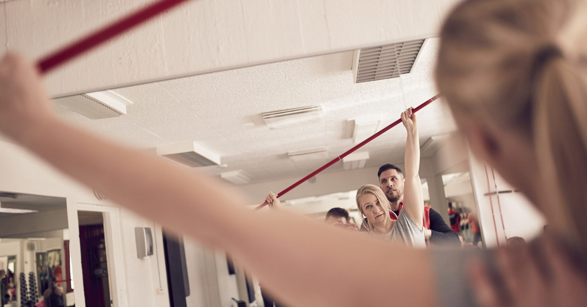 Personal trainer auttaa tekemään lihaskuntolikkeet oikealla tekniikalla.